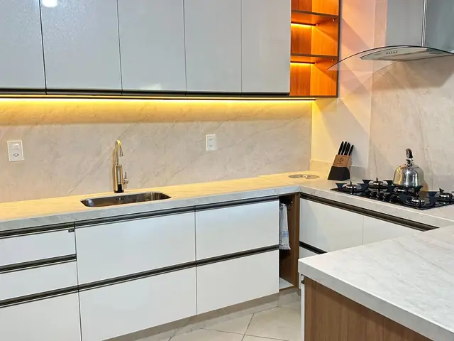 Cozinha com bancada clara e iluminação embutida