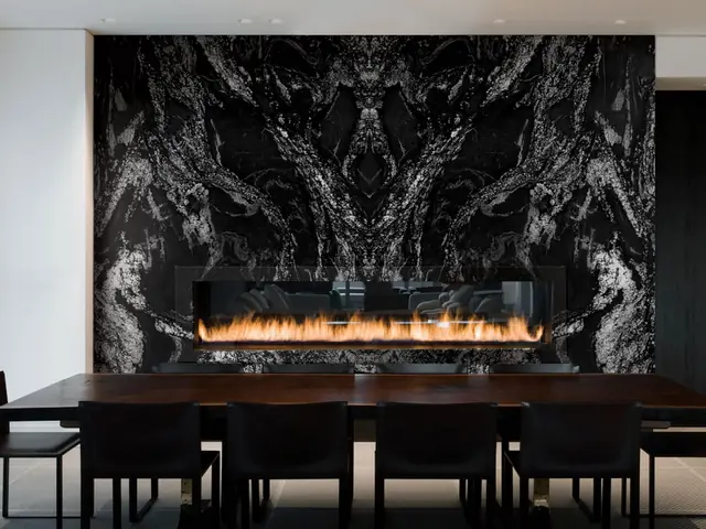 Sala de jantar com lareira revestida em pedra escura
